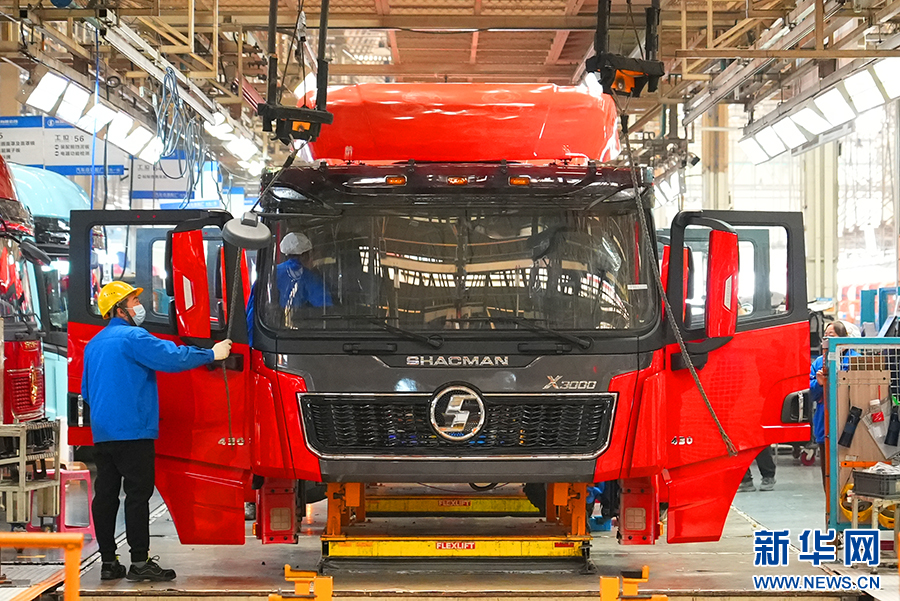 11月14日，在陕汽集团汽车总装配厂车间，两名工人忙着给卡车装配零部件。新华网 杨喜龙 摄