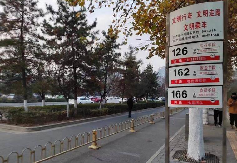 西安欧亚学院公交站台前横着护栏 乘客上下车先跨栏