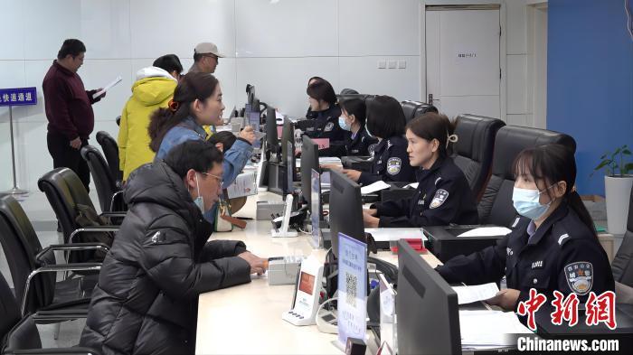 西安市公安局出入境接待大厅内，民众正在服务窗口咨询或办理相关业务。　梅镱泷 摄