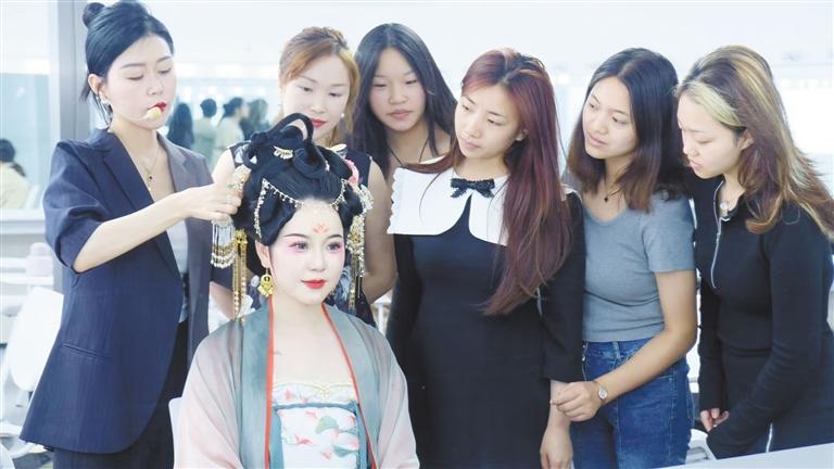 在西安伊凡国际美妆学院,辅导老师向学员讲解发饰的佩戴