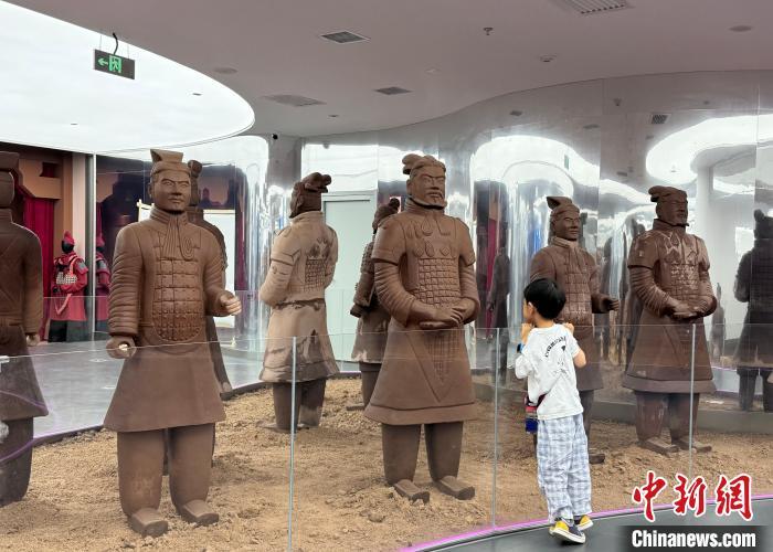 孩童正在仔细观察巧克力“兵马俑”。 李一璠 摄