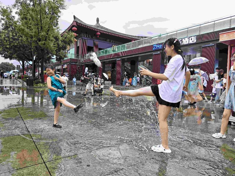 一场阵雨给西安降温 雨后大雁塔北广场上市民戏水