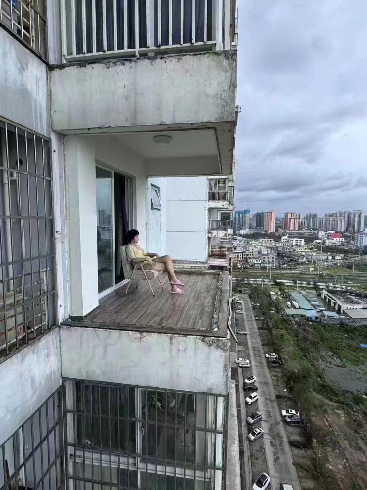 这张台风“摩羯”过后女孩淡定观景的图片火了。