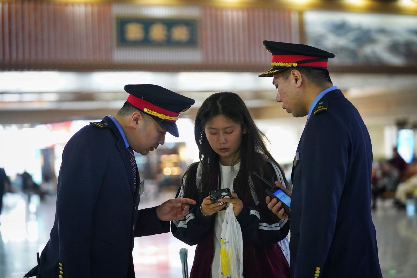 西安火车站工作人员为旅客提供问询解答.jpg