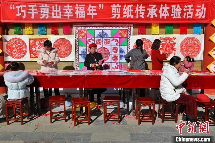 1月26日,陕西省商洛市洛南县民众正在体验剪纸。 陈亚民 摄
