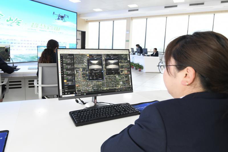 工作人员在鄠邑区秦岭保护总站智慧管控中心监控屏幕前工作。
