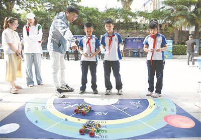 图为在西安市新城区华山实验小学，学生在老师的指导下进行机器人游戏。 新华社记者 张博文摄