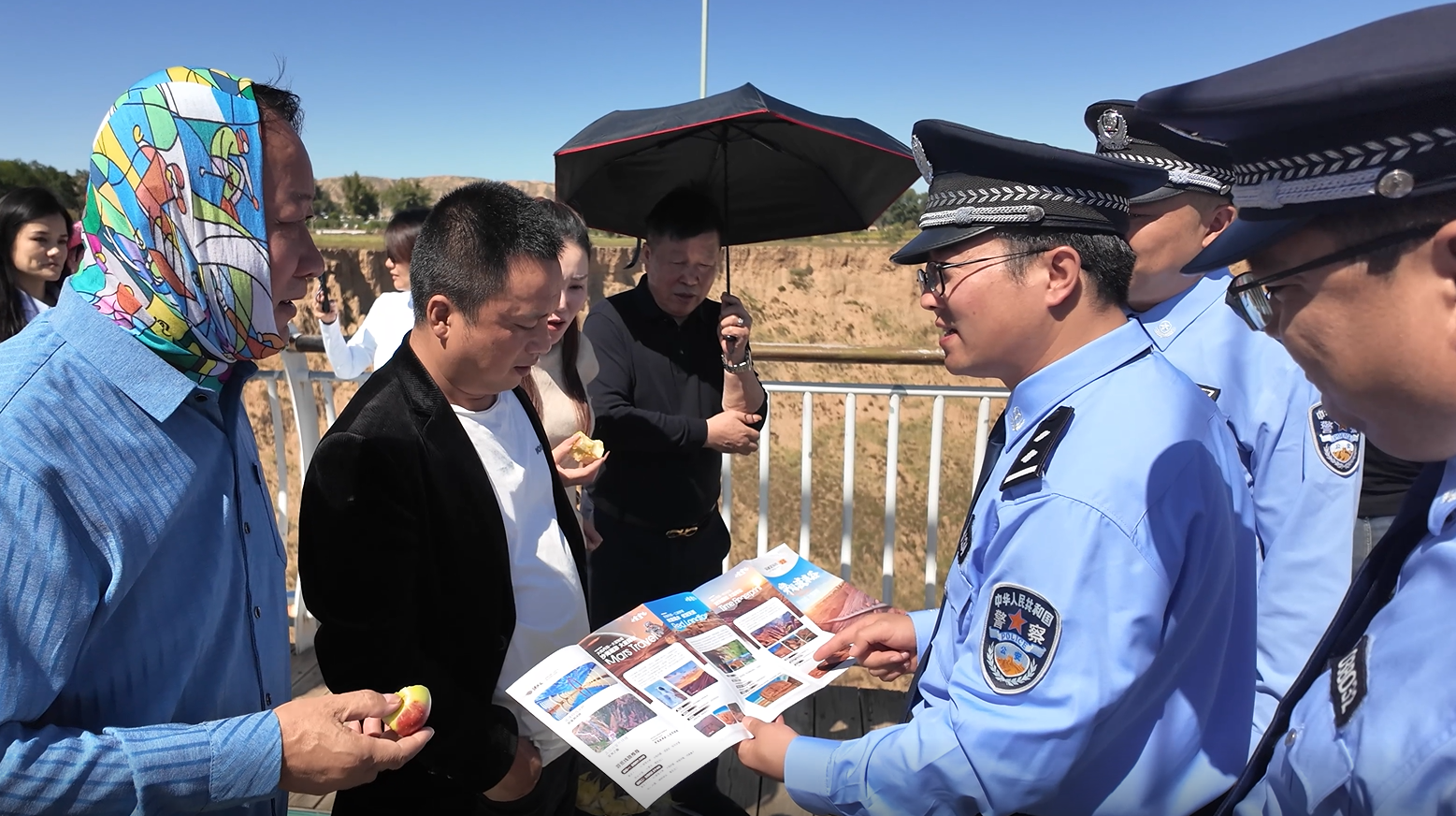A8NcIsbpbQlThb9C.png 靖边县公安局民警在波浪谷丹霞地貌景区为游客讲解安全须知。.png