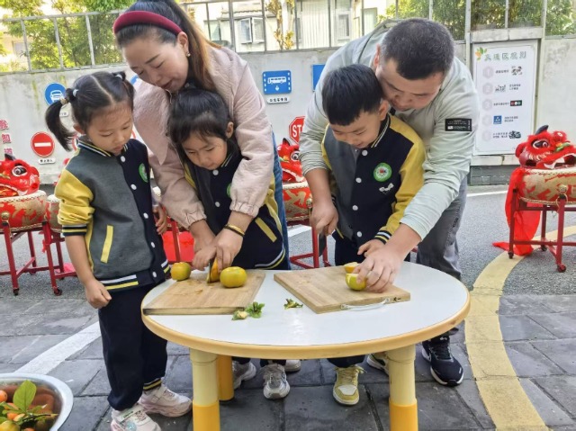 姚安县幼儿园小朋友和家长一起切柿子。吴艳芹摄.jpg