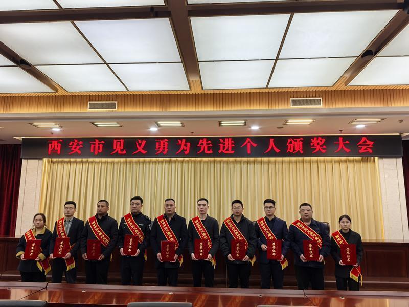 西安市见义勇为先进个人颁奖大会现场，10名见义勇为英雄合影留念。