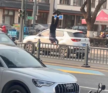 江阴街头一男子在马路隔离护栏上倒立 目击者：他还大声唱歌