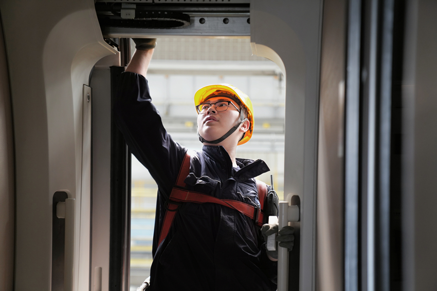 图3 图为动车组机械师邹佩岐正用润滑脂对车门门框进行润滑.jpg