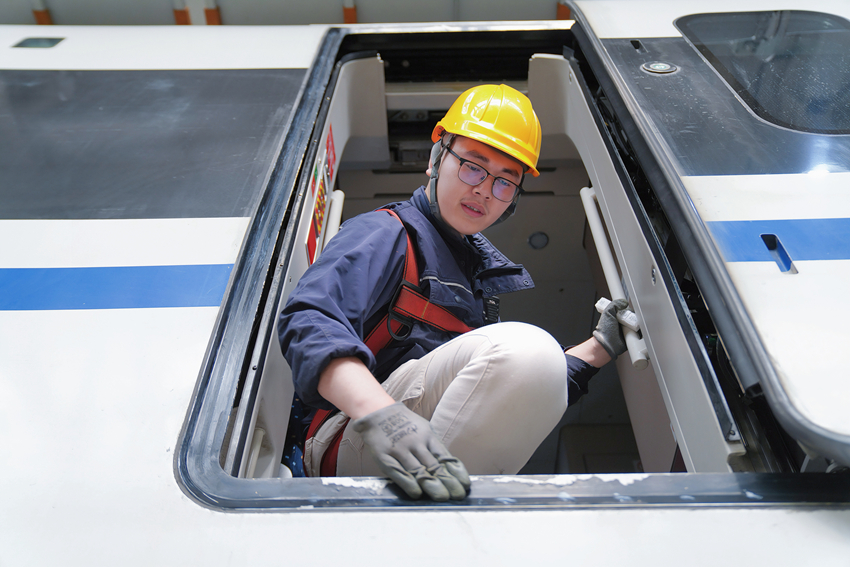 图2 图为动车组机械师邹佩岐正用润滑脂对车门门框进行润滑.jpg