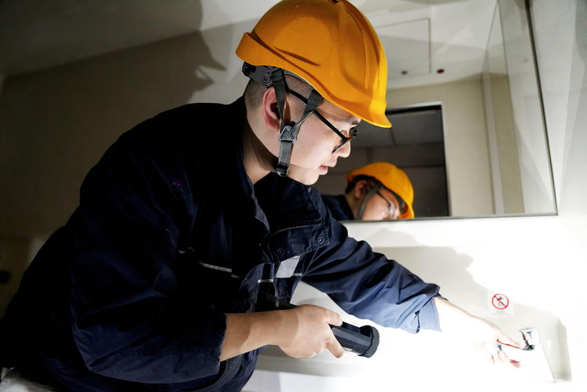 图4 图为动车组机械师邹佩岐对列车厕所水龙头紧固状态进行检查.jpg