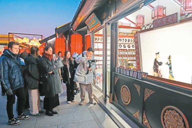 外籍友人被非遗皮影戏表演深深吸引。（记者　谢伟　摄）