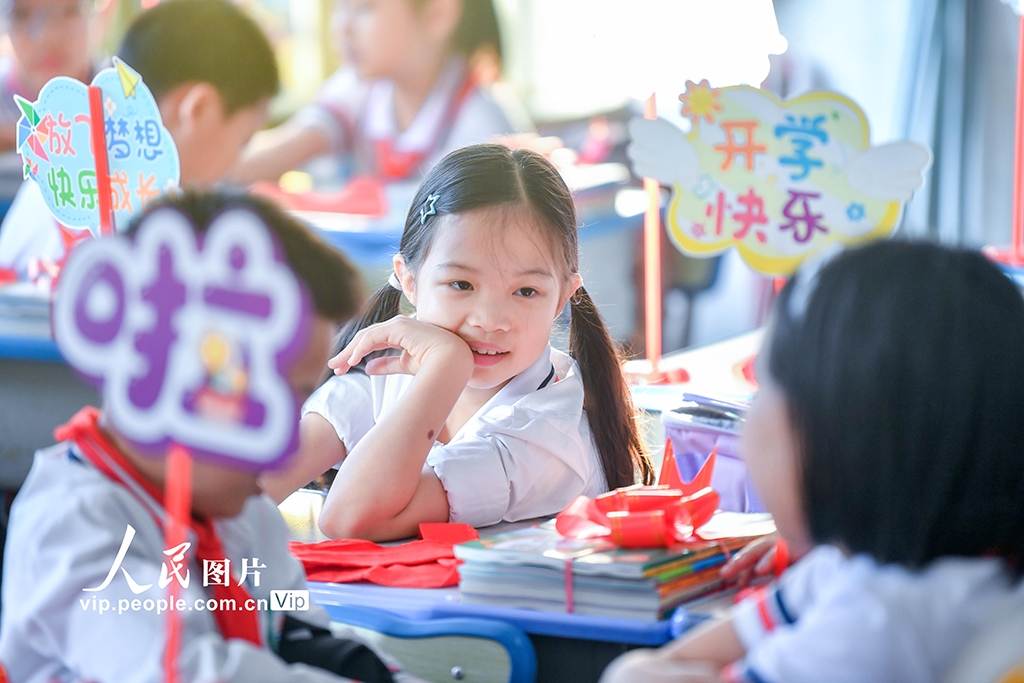 2026年3月1日，海南海口市中小学校学生返校报到。在海口市港湾小学，学校将新课本打包成“新学期礼物”，并为同学们发放崭新的红领巾。苏弼坤摄（人民图片网）