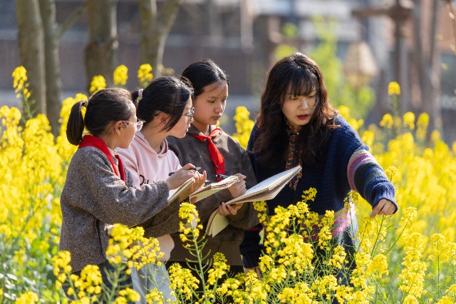 5、2026年3月12日，重庆市南川区金山镇小河坝社区油菜花田春意盎然，美术教师给金山湖小学校的学生们细致讲解写生技巧。.jpg