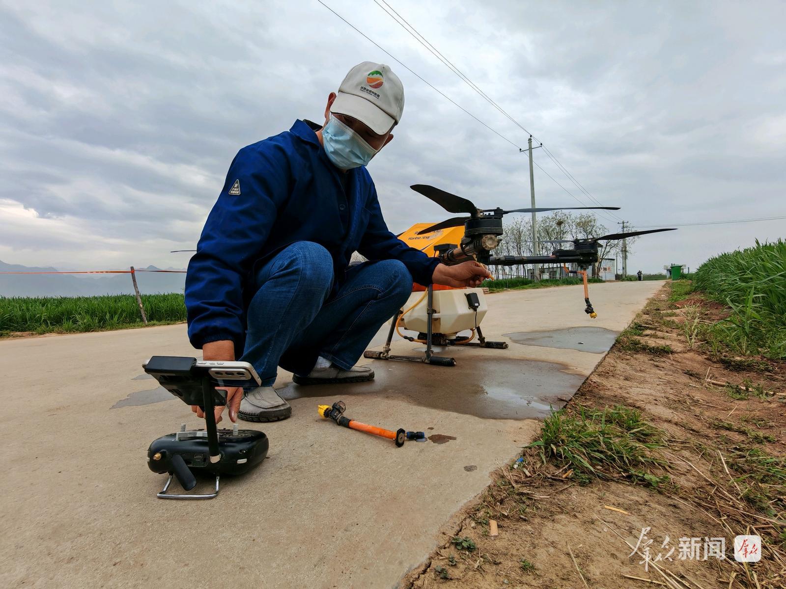 4月11日,在西安市长安区王曲街道中江兆村,长丰农机专业合作社飞手正在调试无人机。群众新闻记者 王海涛摄