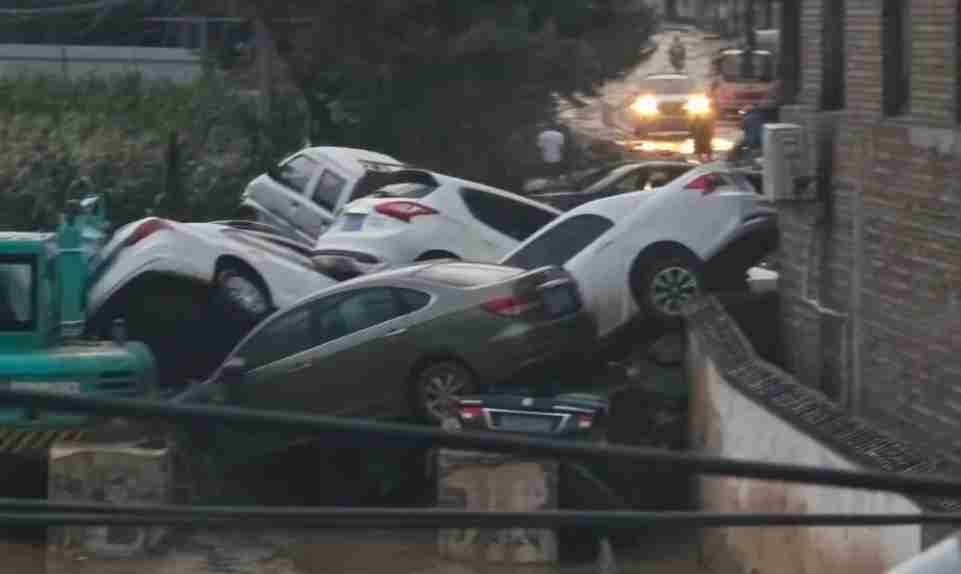 山西吕梁一路口因暴雨致多辆私家车堆叠 道不少人来寻车