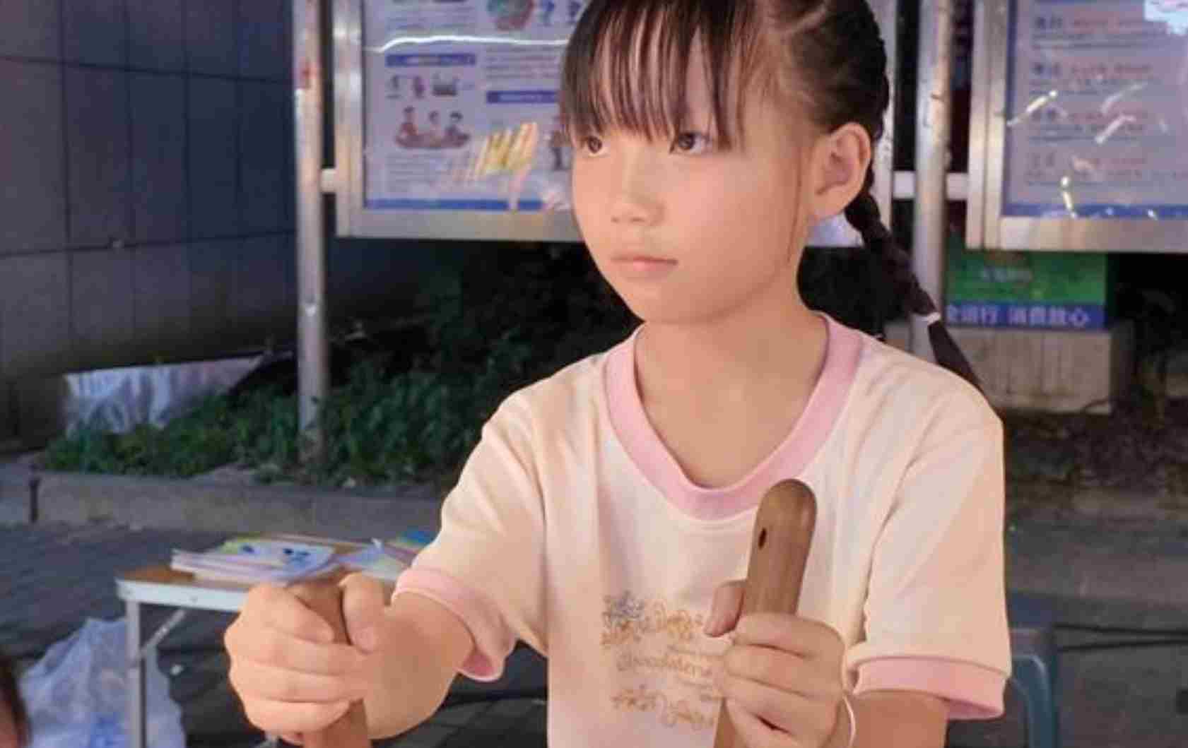 7岁女孩来长沙帮爸妈守摊 身高不够站在凳子上招待客人