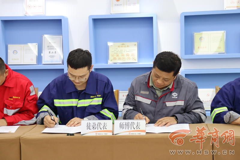 4全国劳动模范、中煤新集能源股份有限公司首席技师曹学涛(右)与陕煤黄陵矿业有限公司职工签订师徒协议.JPG